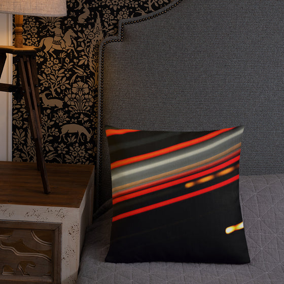 Black square designer pillow with streaking red and yellow lights going across
