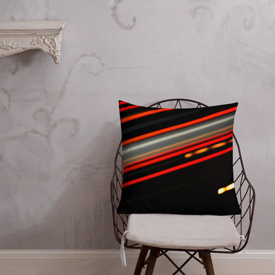 Black square designer pillow with streaking red and yellow lights going across