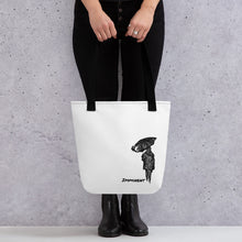  White tote bag with black straps with the graphic of a woman holding an umbrella walking away and the text reading IMMINENT