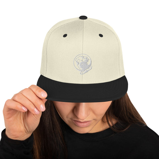 Cream baseball hat with logo of a man's face behind the moon