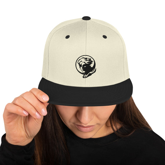 Cream baseball hat with logo of a man's face behind the moon