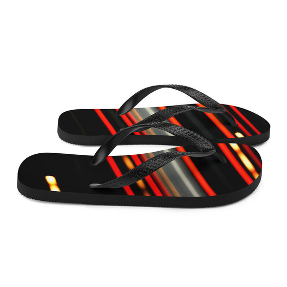 Designer flip flops of red and yellow streaking lights across a black background