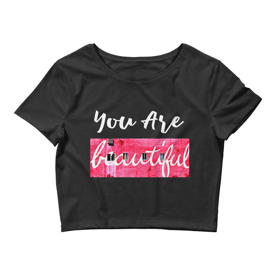 Black crop top that says YOU ARE BEAUTIFUL with a photograph of a pink wall behind beautiful